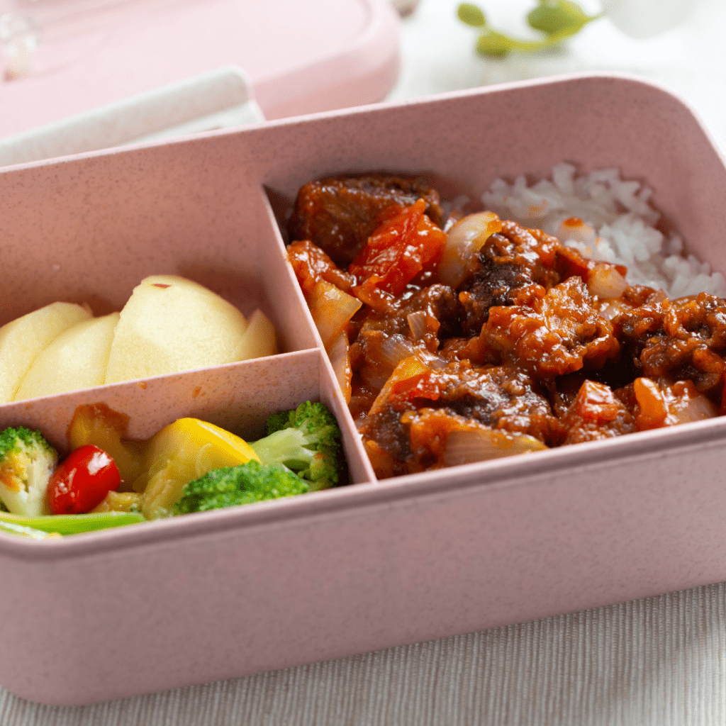 Healthy school lunch ideas for teens, including a bento box with grilled chicken, whole-grain crackers, and fresh vegetables, perfect for athletes