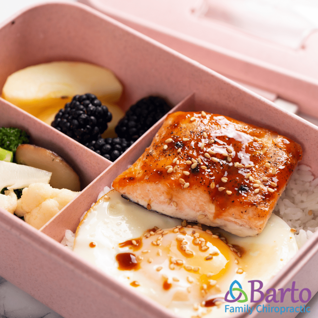 Easy and nutritious meal prep for teenage athletes, showing a balanced power bowl with quinoa, salmon and egg, and steamed veggies and fresh fruit.